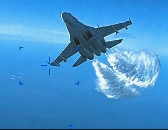 Foto tomada de un video divulgado el 16 de marzo de 2023 que muestra un Su-27 ruso arrojandro combustible a un dron sobre el Mar Negro, según el Pentágonom(Imagen VOA).